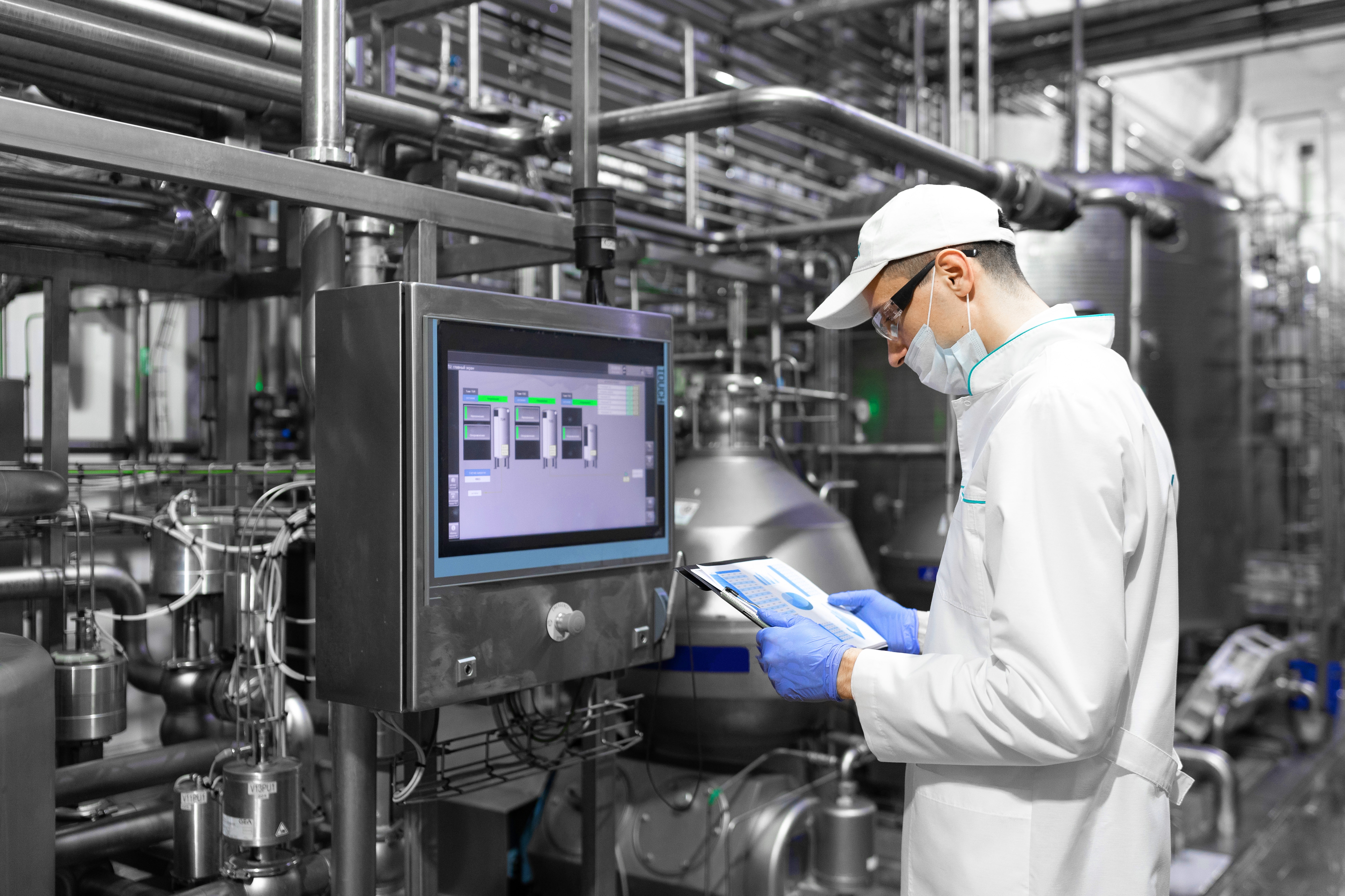 man in a white robe and a cap analyzing digital screen